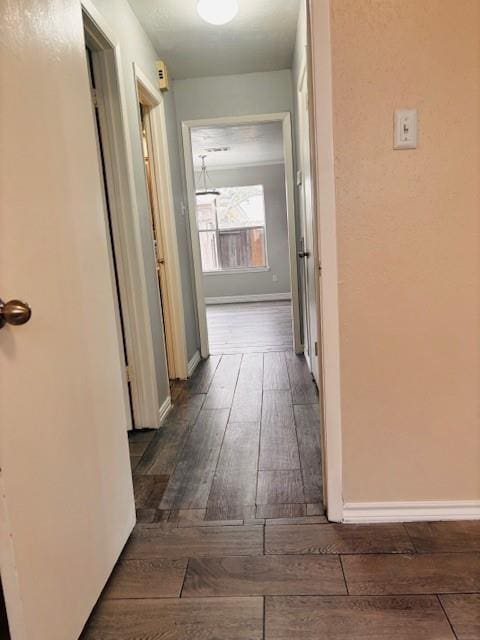 hall with baseboards and dark wood-type flooring