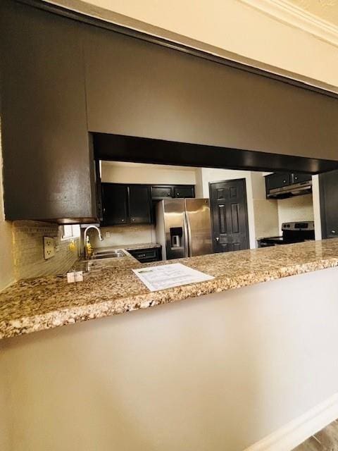 kitchen with tasteful backsplash, appliances with stainless steel finishes, ornamental molding, dark cabinetry, and a sink