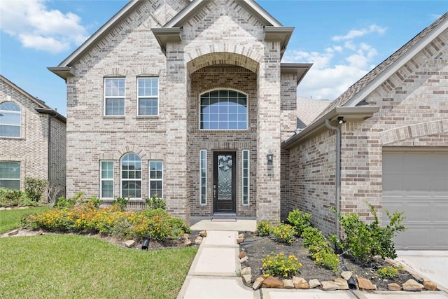 doorway to property with brick siding and an attached garage