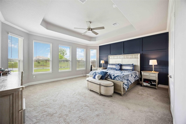 bedroom featuring carpet, baseboards, visible vents, crown molding, and a tray ceiling
