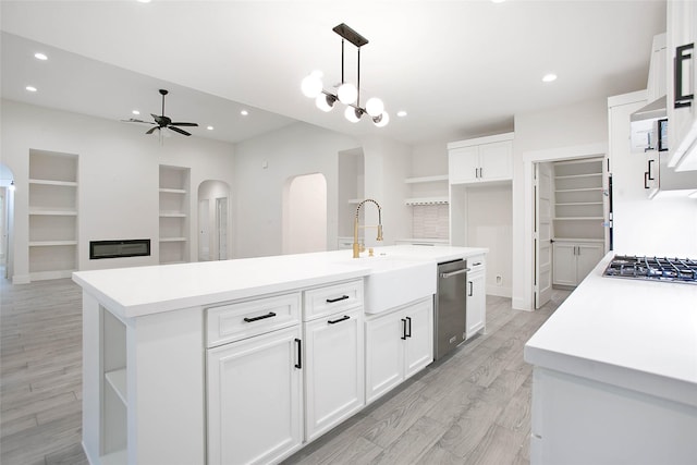 17522 Julianne Dr, Waller, TX 77484 - kitchen with a sink, stainless steel appliances, open shelves, a ceiling fan, and arched walkways