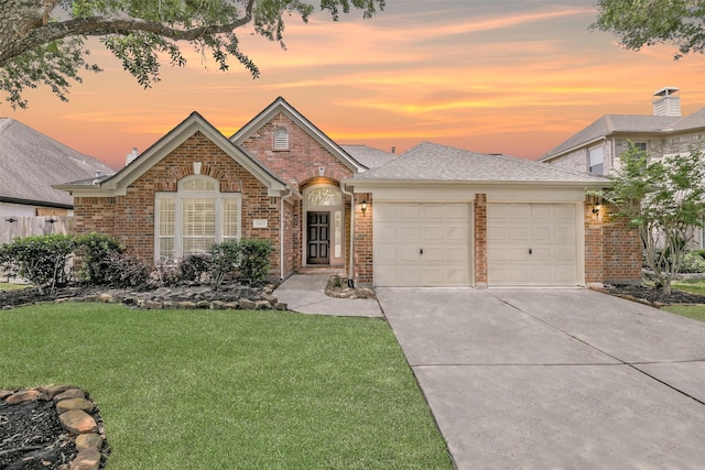 7403 Hickory Canyon Ct, Humble, TX 77396 - view of front of house with driveway, a shingled roof, a lawn, brick siding, and a garage