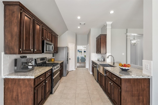 7403 Hickory Canyon Ct, Humble, TX 77396 - kitchen featuring decorative backsplash, a sink, visible vents, stainless steel appliances, and dark brown cabinetry