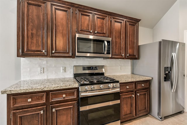7403 Hickory Canyon Ct, Humble, TX 77396 - kitchen with dark brown cabinetry, stainless steel appliances, and backsplash