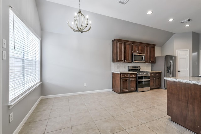 7403 Hickory Canyon Ct, Humble, TX 77396 - kitchen with stainless steel appliances, a notable chandelier, light stone counters, backsplash, and lofted ceiling