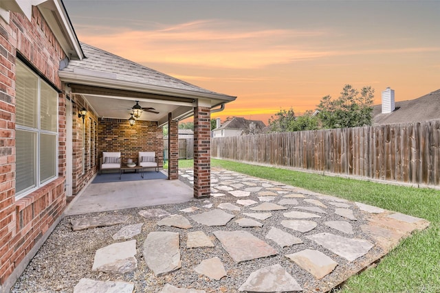 7403 Hickory Canyon Ct, Humble, TX 77396 - patio terrace at dusk with ceiling fan and a fenced backyard