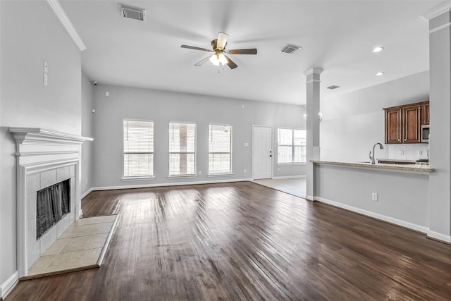 7403 Hickory Canyon Ct, Humble, TX 77396 - unfurnished living room with dark wood-style floors, a tile fireplace, a ceiling fan, and visible vents
