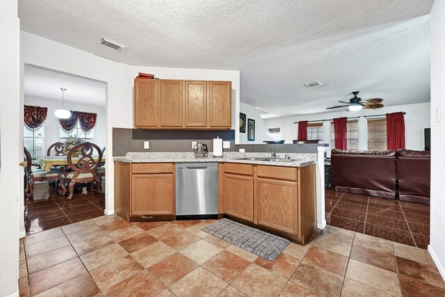 kitchen featuring a sink, dishwasher, a peninsula, and visible vents