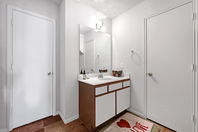 bathroom with tile patterned floors, vanity, and baseboards