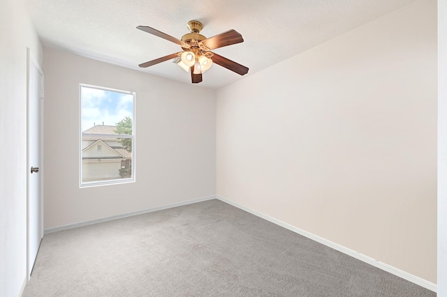 spare room featuring baseboards, a ceiling fan, and carpet