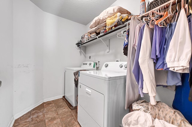 clothes washing area with baseboards, laundry area, and washing machine and dryer