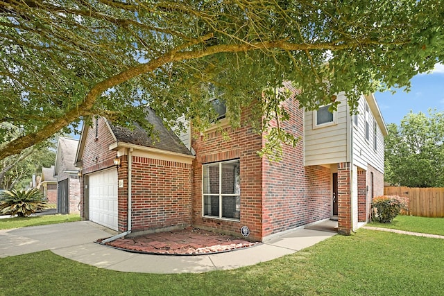 view of front of house with brick siding, fence, a front lawn, and concrete driveway