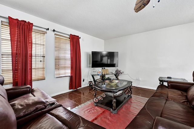 tiled living area featuring baseboards and a textured ceiling