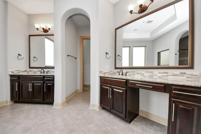 bathroom with decorative backsplash, visible vents, tile patterned flooring, two vanities, and a sink
