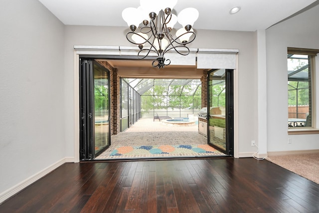 doorway to outside with an inviting chandelier, recessed lighting, baseboards, and hardwood / wood-style floors