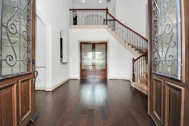 entryway featuring stairway, baseboards, french doors, and dark wood-style flooring