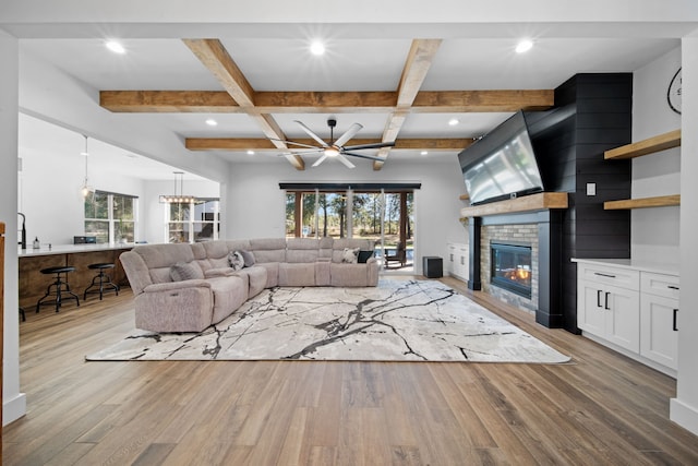 31 Quiet Springs Trl, Willis, TX 77378 - living area featuring wood finished floors, healthy amount of natural light, a fireplace, a chandelier, and beamed ceiling