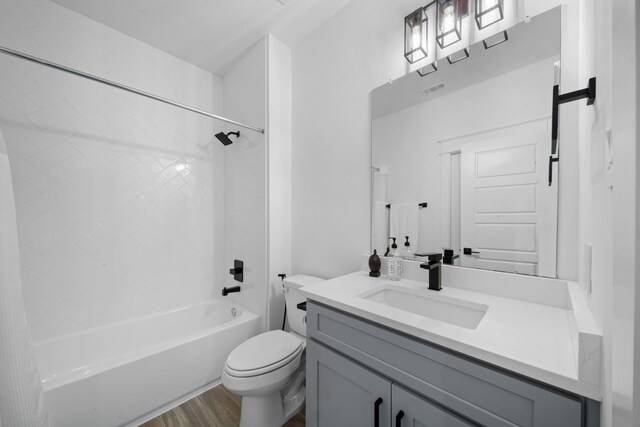 full bath with wood finished floors, toilet, vanity, visible vents, and shower / tub combo with curtain
