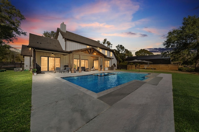 outdoor pool featuring a lawn, fence, and a patio