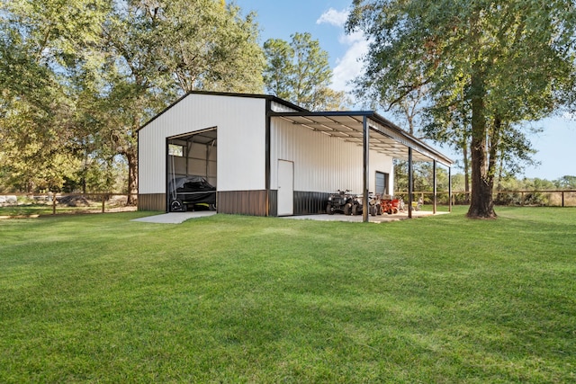 view of pole building with a lawn and fence