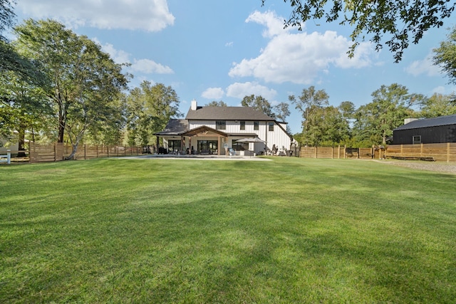 rear view of house featuring fence, a gazebo, and a lawn