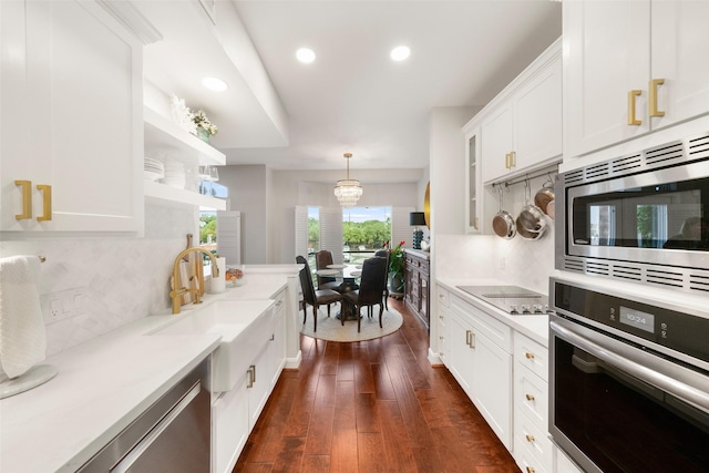 452 Mariners Dr, Kemah, TX 77565 - kitchen with decorative backsplash, white cabinets, a sink, stainless steel appliances, and light countertops