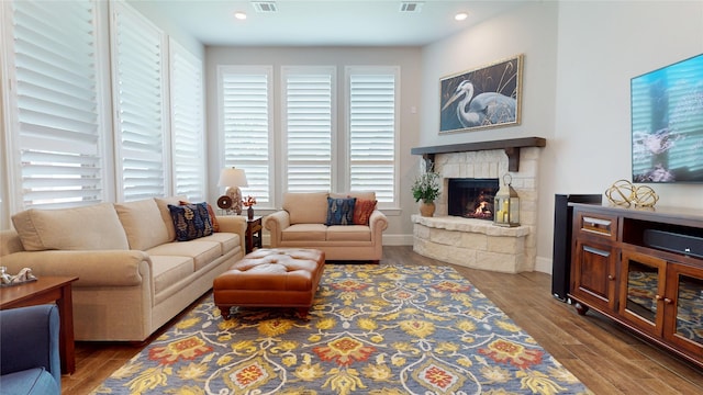 living room with visible vents, a fireplace, wood finished floors, baseboards, and recessed lighting