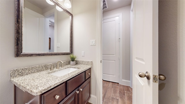 bathroom with vanity, baseboards, and wood finished floors
