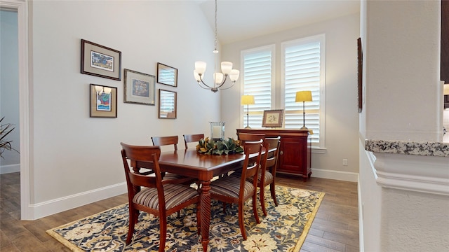 dining room featuring baseboards, wood finished floors, and a chandelier
