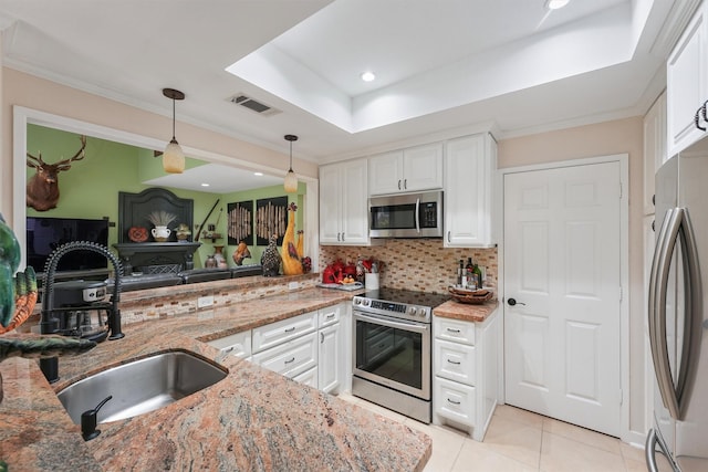 kitchen featuring light stone counters, a sink, stainless steel appliances, visible vents, and pendant lighting