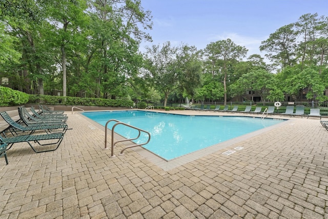 pool featuring fence and a patio area