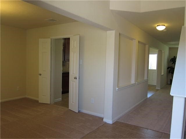 interior space featuring carpet, visible vents, and baseboards