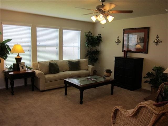 living room with light colored carpet and ceiling fan