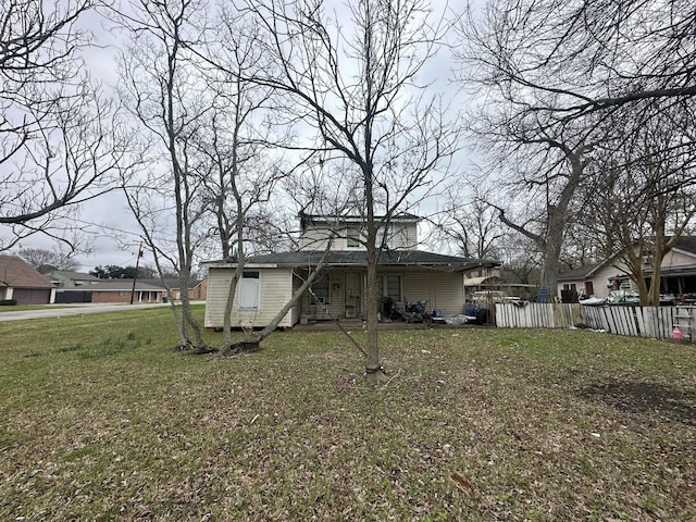 back of property featuring fence and a yard