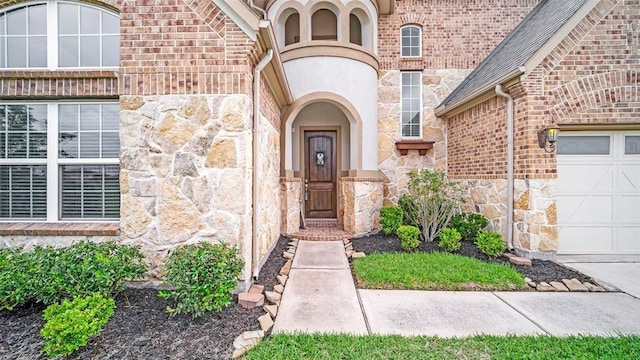 entrance to property featuring stone siding and a garage