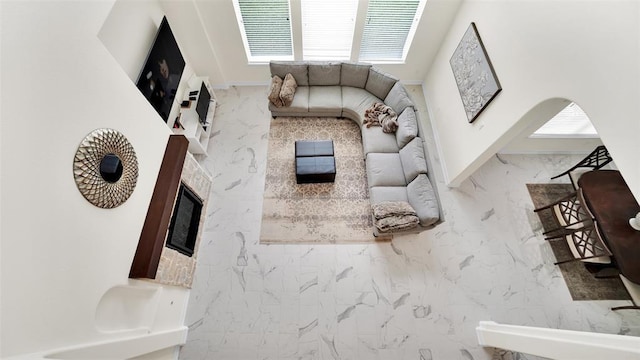 unfurnished living room featuring marble finish floor and arched walkways