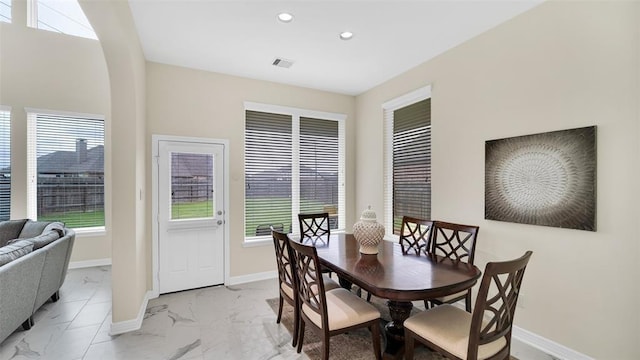 dining area with marble finish floor, visible vents, and a healthy amount of sunlight