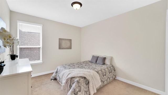 bedroom with light carpet and baseboards