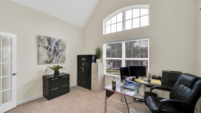 office space with high vaulted ceiling and light colored carpet