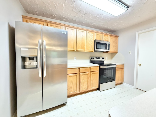 8051 Bay Branch Dr Unit 424, The Woodlands, TX 77382 - kitchen with light countertops, light floors, light brown cabinets, and stainless steel appliances