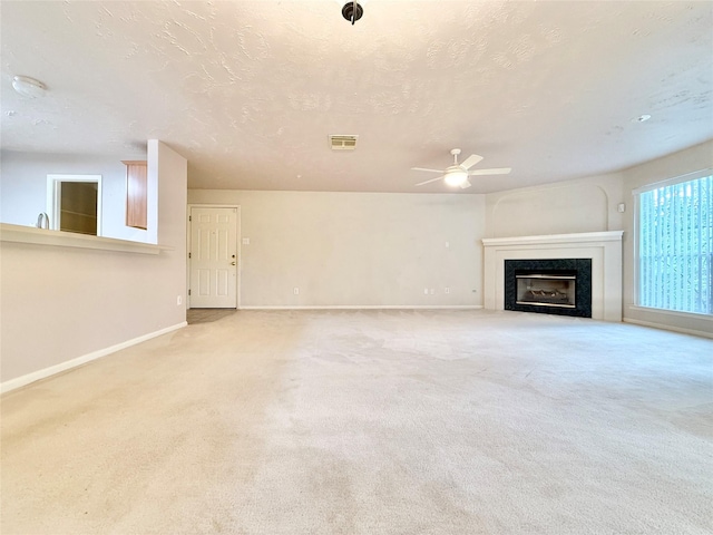 unfurnished living room featuring carpet flooring, baseboards, visible vents, and ceiling fan