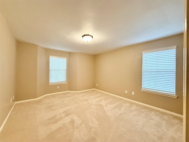 carpeted empty room featuring baseboards