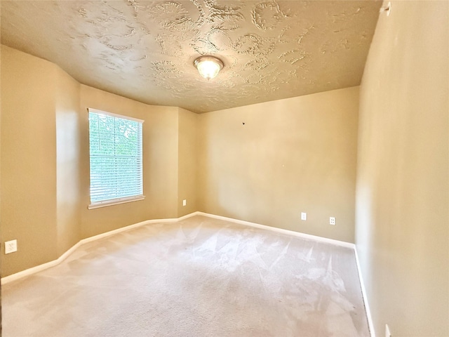 carpeted empty room with baseboards and a textured ceiling