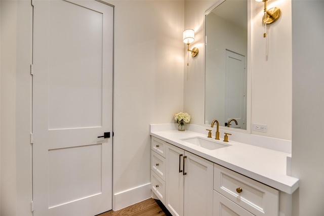 bathroom featuring wood finished floors, vanity, and baseboards