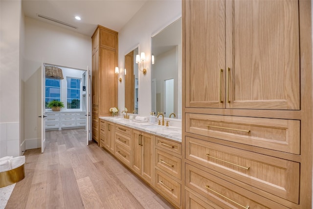 bathroom featuring vanity, visible vents, and wood finished floors