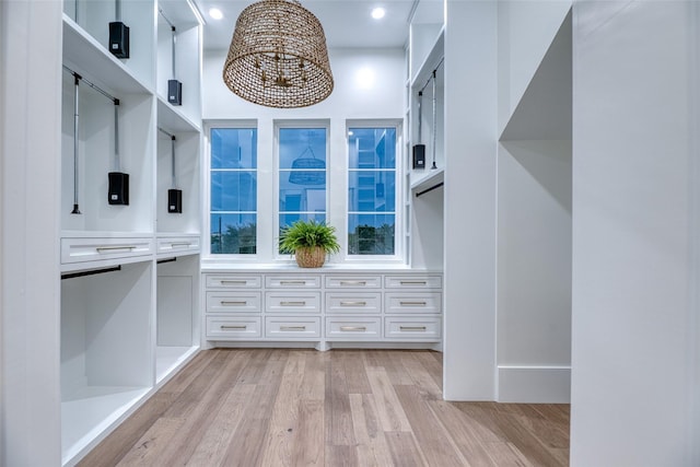 walk in closet with light wood-style flooring