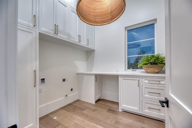 laundry area with hookup for an electric dryer, cabinet space, light wood-style floors, hookup for a gas dryer, and hookup for a washing machine