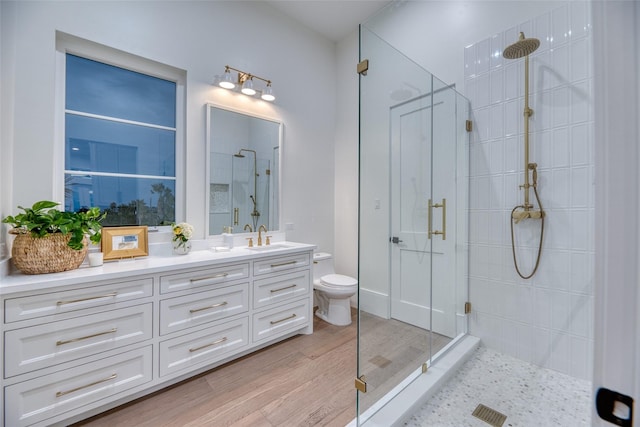 full bath featuring vanity, toilet, a stall shower, visible vents, and wood finished floors