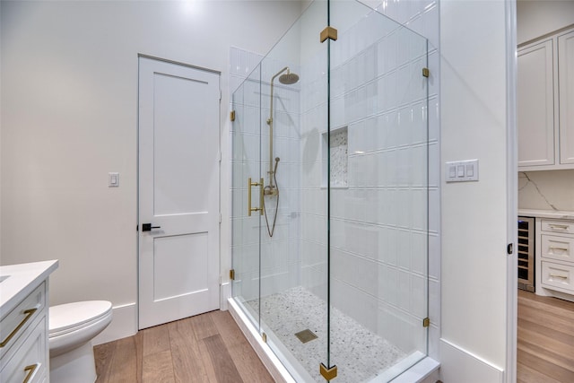 full bath featuring a stall shower, vanity, wood finished floors, and beverage cooler