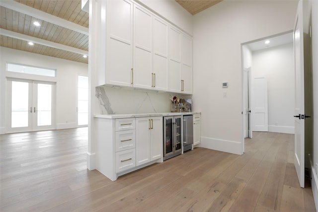 426 81st St, Galveston, TX 77554 - bar with baseboards, a dry bar, beam ceiling, light wood finished floors, and wine cooler